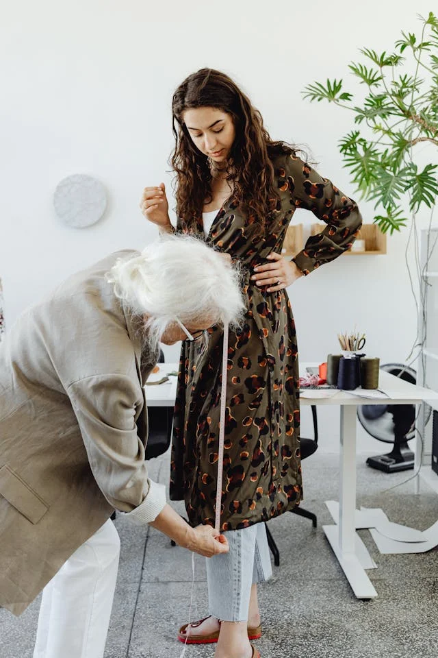 Woman in Beige blazer measuring a womans dress length